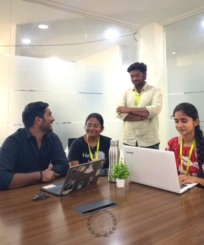 A mentor with learners around laptops at the desk